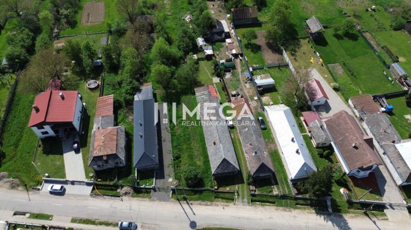 Letecký pohled na pozemky k bydlení v Sennom se zahradami a domy.