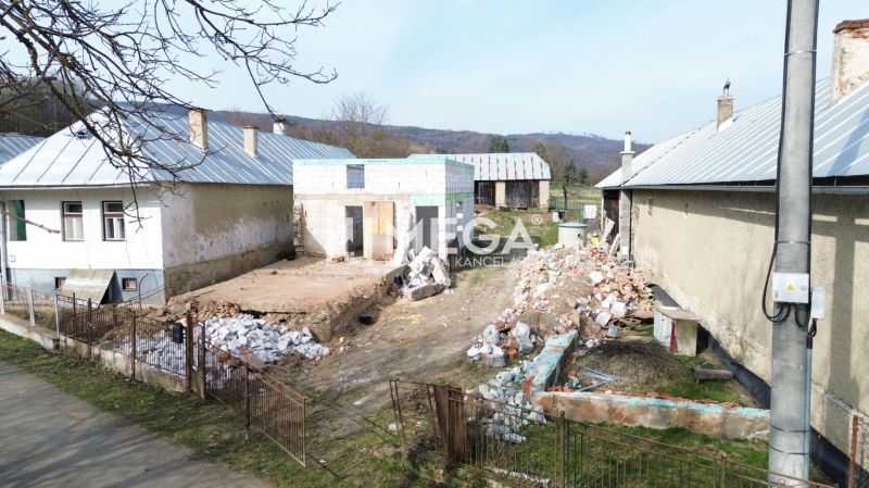 Rodinný dům v Zbojném v rekonstrukci, okolí s hromadami stavebního materiálu.