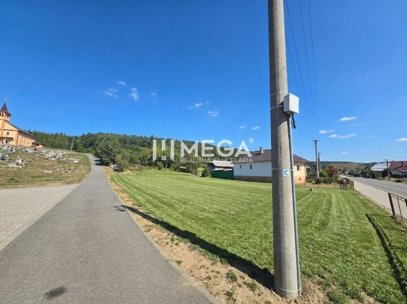 Cesta ve Slovenské Volové se zelení, domy a kostelem, Pozemky - bydlení.