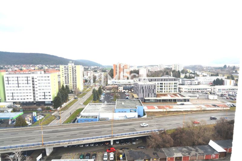 Město Humenné, ulice Štefánikova, zobrazuje výhled na obchodní prostory a dálnici.
