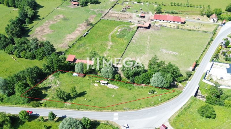 Pozemky - bydlení v Ptičom, obklopené zelení u hlavní silnice.