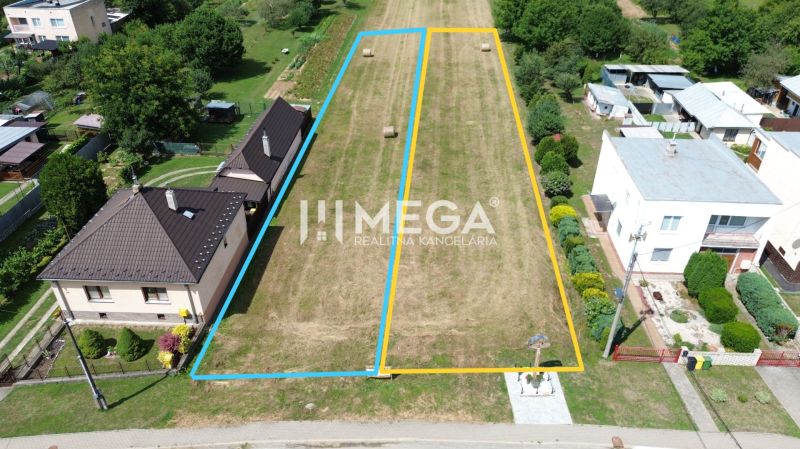 Pozemky - bydlení v Jasenově, ohraničené parcely, travnatý terén s několika stromy.