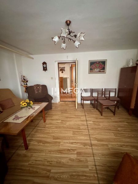 Obývací pokoj v rodinném domě s podlahou s dřevěným dekorem a nábytkem.