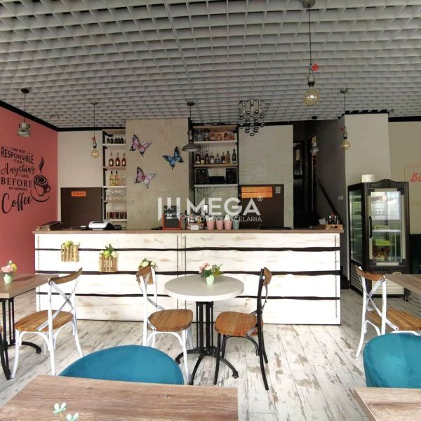 Kavárna s dřevěným dekorem, stoly a židlemi, ozdobené stěnami v gastro prostoru.