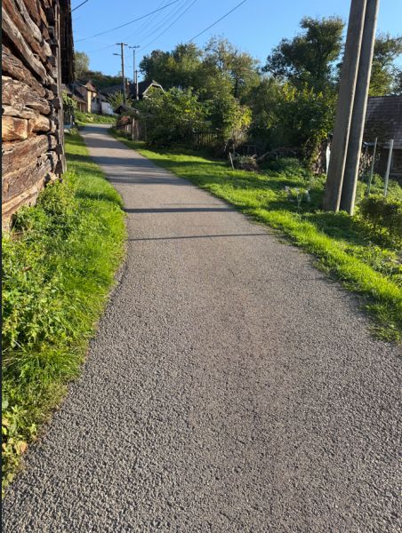Cesta mezi domy v Košeckém Podhradí s pozemky na bydlení.