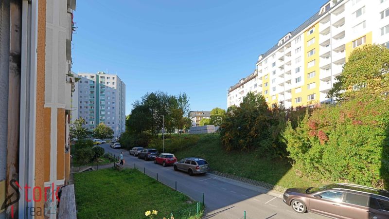 Ulice Rozkvet, Považská Bystrica, s bytovými domy a zaparkovanými auty u 3pokojového bytu.