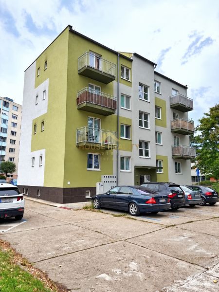 Bytový dům na Andrusovově ulici, Bratislava - Petržalka se zaparkovanými auty před budovou.
