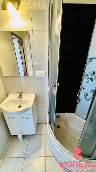 Koupelna s umyvadlem a sprchovým koutem v 1-pokojovém bytě.