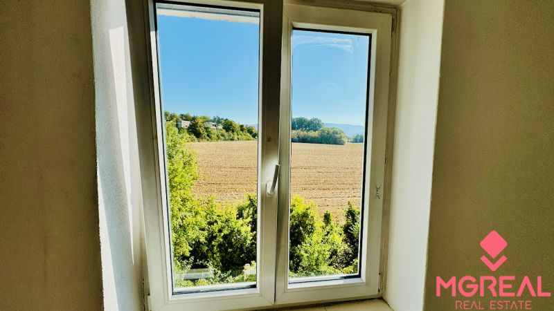Pohled z 1-pokojového bytu na pole a zeleň v Malých Kršteňanech.