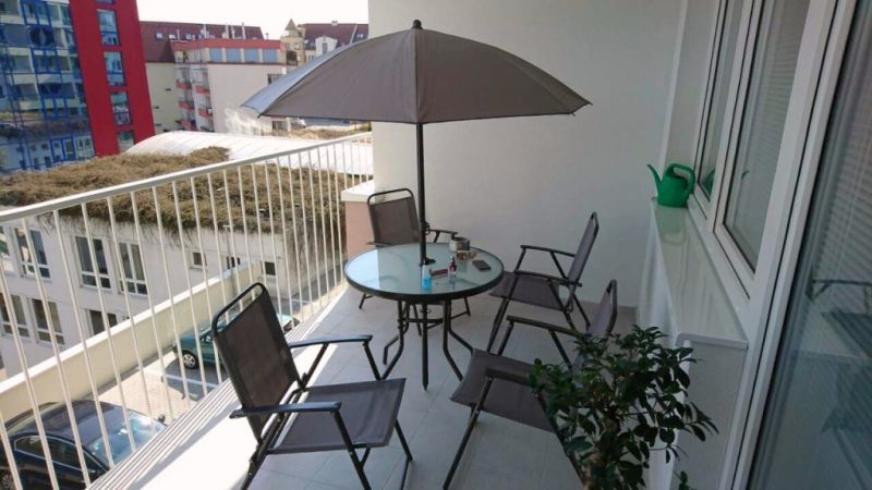 Balkon 3pokojového bytu Nad Plážou v Banské Bystrici s posezením a slunečníkem.