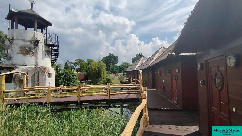 Chata u Seneckých jezer s dřevěnými prvky a věžovitou stavbou v zahradě.