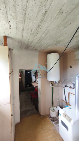 Koupelna v rodinném domě s bojlerem a kotelnou, dlažba na podlaze.