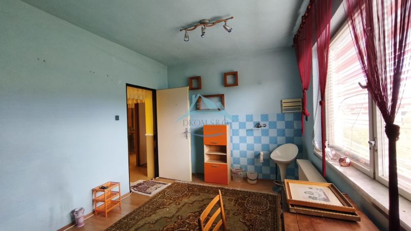 Pokoj v rodinném domě s kachličkami, podlahou s dřevěným dekorem a velkým oknem.