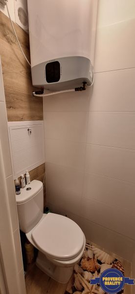 Toaleta s podlahou s dřevěným dekorem v 3-pokojovém bytě.