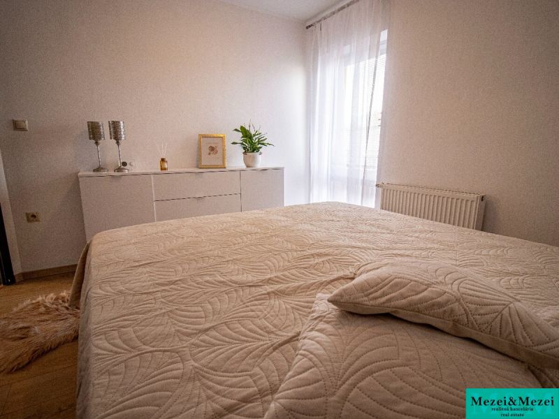 Ložnice s bílým nábytkem a dekorativními doplňky v rodinném domě.