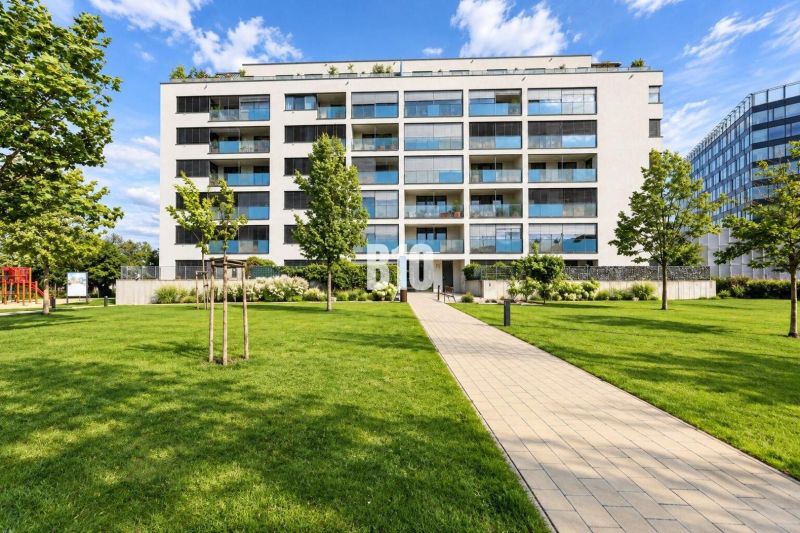 Budova s moderními balkony, obklopená zelení na Malokrasňanské ulici v Bratislavě III.