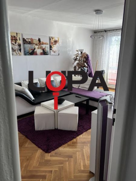 Pohodlný obývací pokoj s podlahou s dřevěným dekorem ve vyhledávaném 2pokojovém bytě.