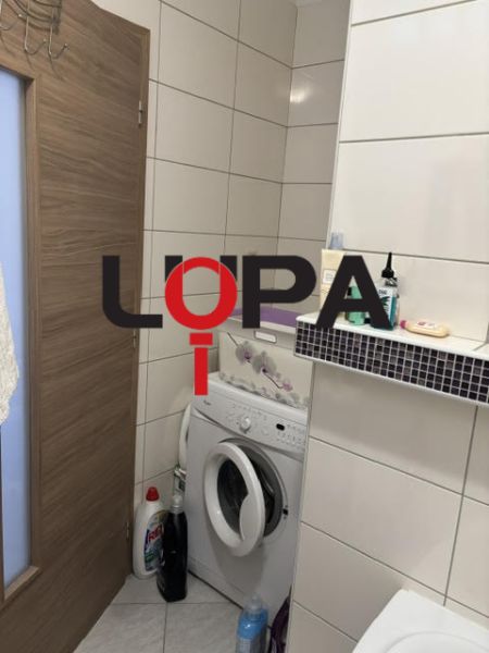 Koupelna v 2-pokojovém bytě s pračkou a úložným prostorem.