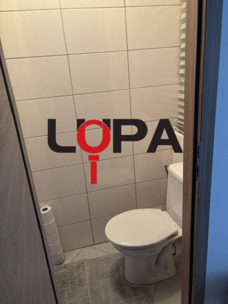 Toaleta s jednoduchým obkladem a dlažbou v 2-pokojovém bytě.