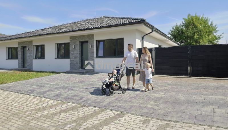 Rodinný dům v Hôrce nad Váhom s rodinou na dlážděné příjezdové cestě.