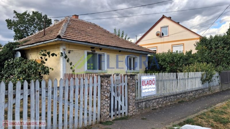 Rodinný dům v Tornyosnémeti s cihlovou střechou a barevným plotem.