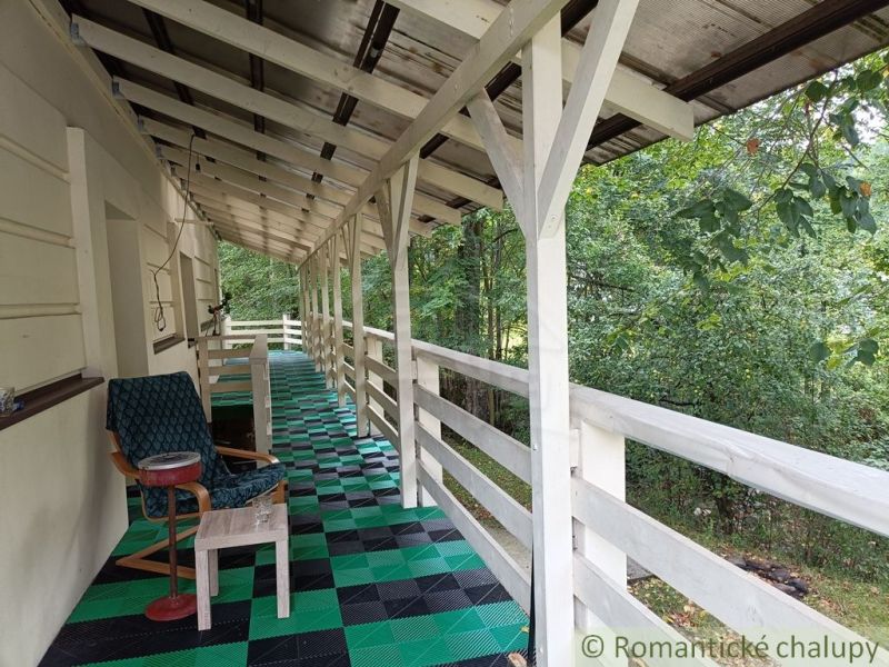 Veranda rodinného domu ve Staškově s barevnou podlahou a výhledem na zeleň.