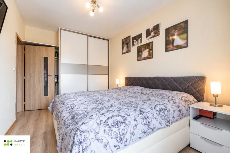 Ložnice s vestavěnou skříní, v 3-pokojovém bytě; podlaha s dřevěným dekorem.