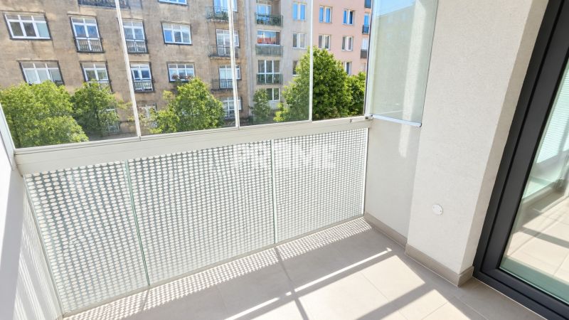 Balkon s výhledem na ulici v 2pokojovém bytě s moderním zábradlím.