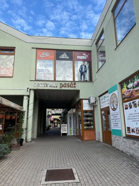 Obchodní prostory v Topoľčanech se vstupem do centra pasáže a pohledem na vitríny.