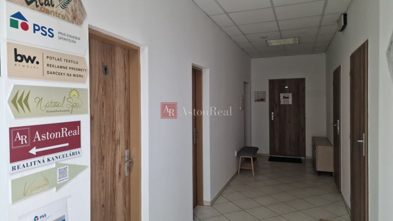 Kanceláře s bílými stěnami a dveřmi s dřevěným dekorem pro různé firmy.