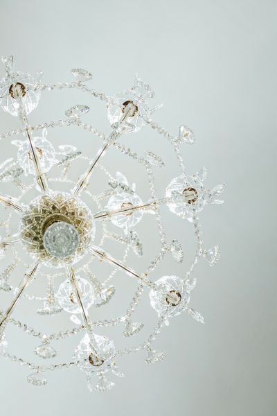 Luxusní křišťálový lustr s komplikovanými detaily v obchodních prostorách.