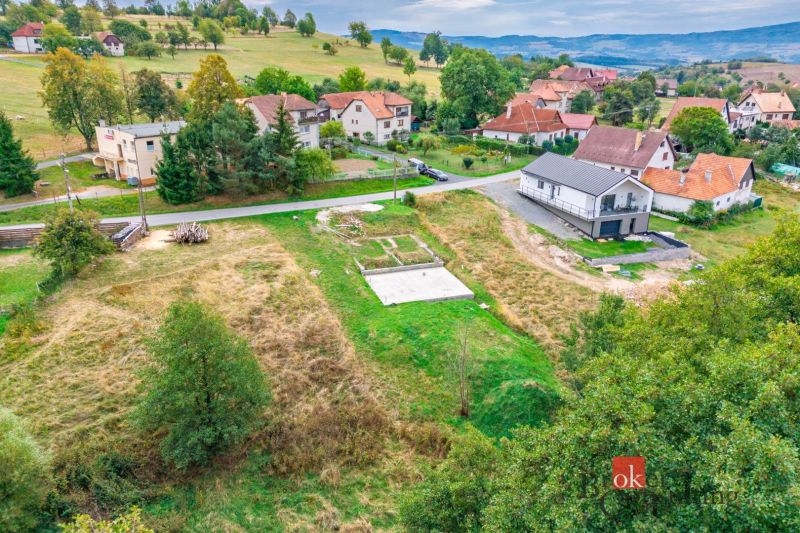 Pozemky - bydlení v Detvě s výhledem na okolní domy a přírodní scenérii.