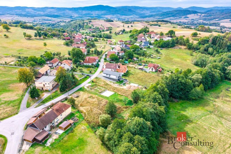 Letecký pohled na obytné pozemky ve městě Detva s okolní přírodou a budovami.