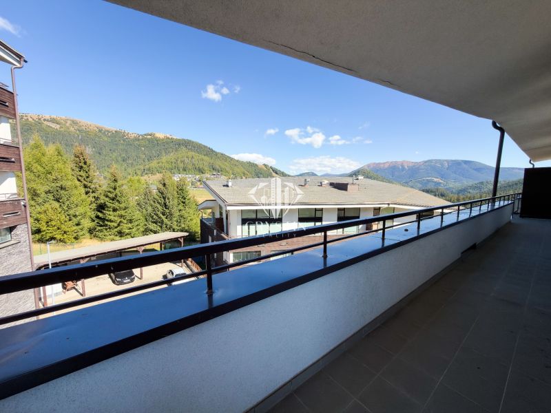Balkon 3pokojového bytu v Donovalech nabízí výhled na hory a střechy budov.