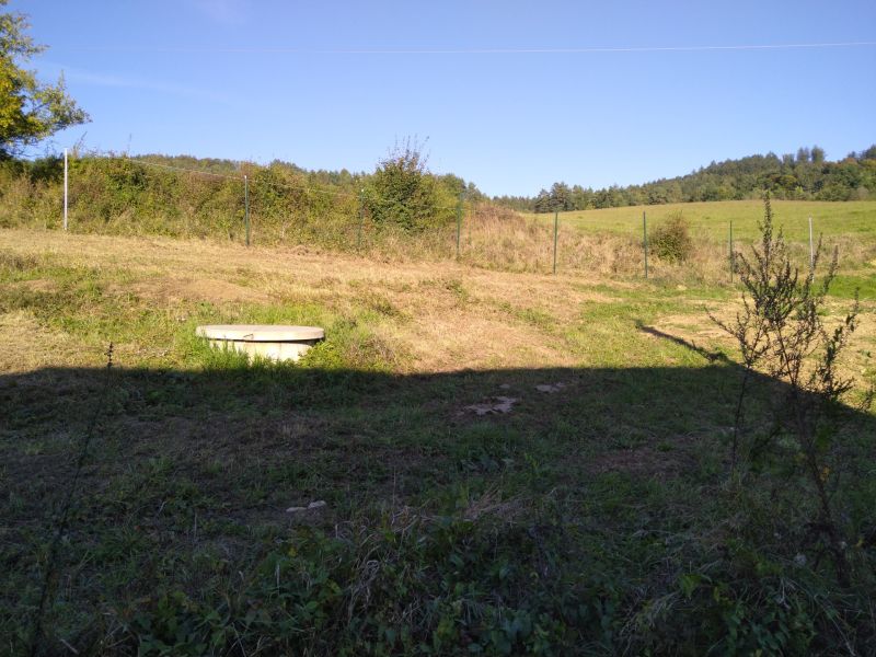 Krajina v Horní Breznici u chaty, louka obklopená přírodou a plotovou bariérou.