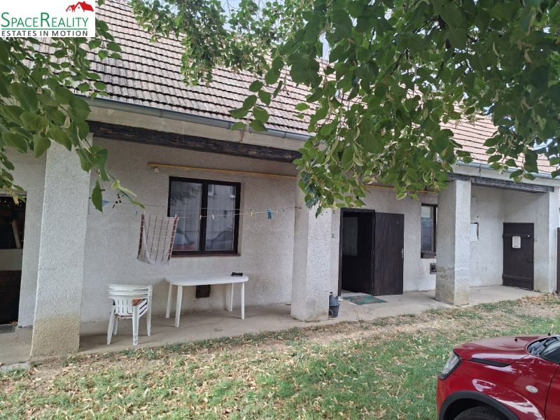 Před domem na Hlavní ulici ve Viničném, Pozemky - bydlení, stojí stoly.