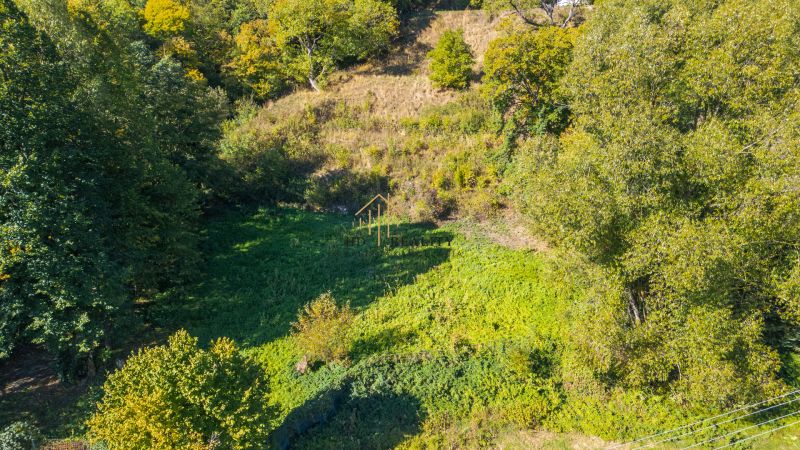 Rekreační pozemky v Štiavnických Baniach obklopené hustou vegetací a stromy.