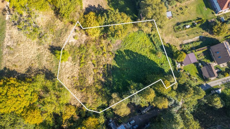 Letecký pohled na rekreační pozemky v Štiavnických Baních obklopené zelení a sousedními zahradami.