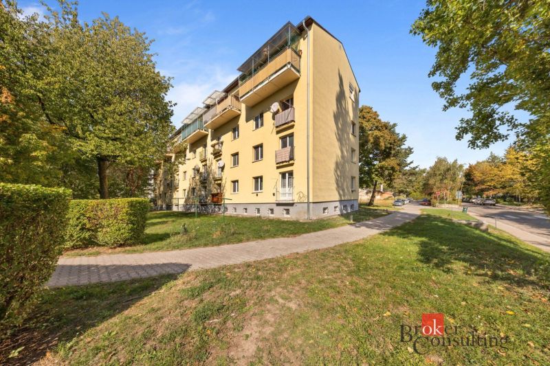 Bytový dům na ulici Hubeného v Bratislavě-Rači obklopený zelení a silnicí.