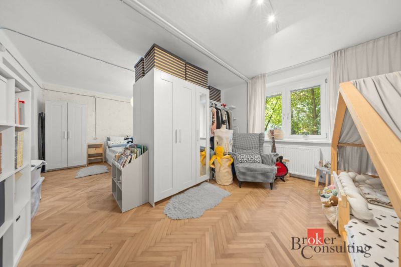 Dětský pokoj v 2pokojovém bytě s otevřeným prostorem a podlahou s dřevěným dekorem.
