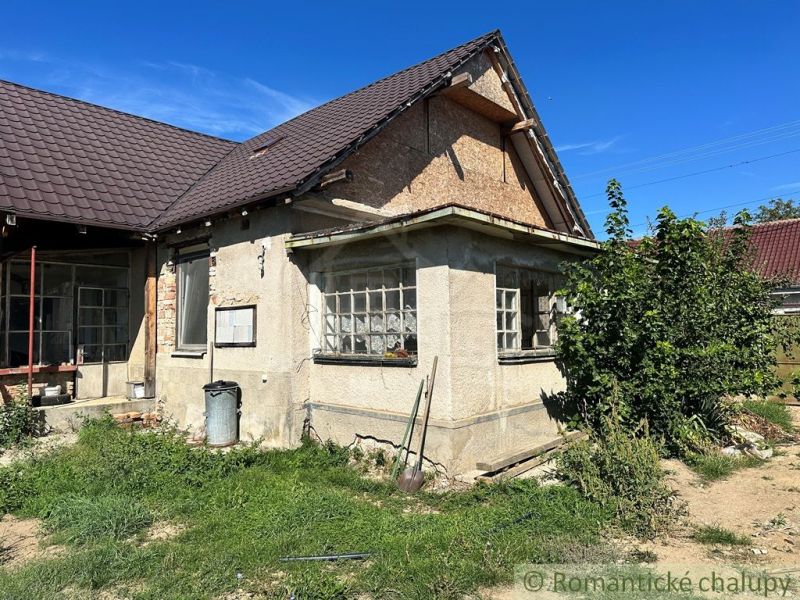 Rodinný dům ve Vištuku s jednoduchými fasádními detaily a travnatým pozemkem.