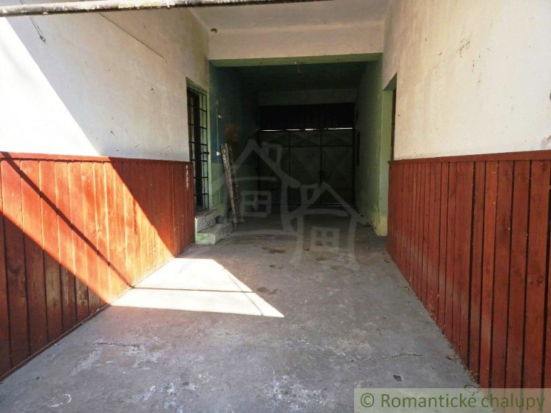 Garáž v obchodních prostorách Modrého Kamene se stěnami s dřevěným obkladem.