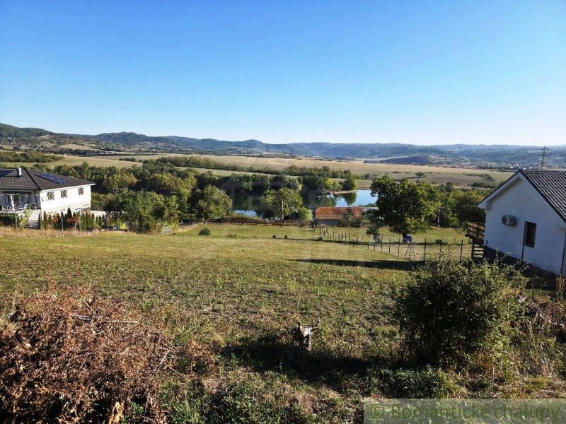 Výhled na jezero obklopené domy a kopci v zahradách Krupiny.
