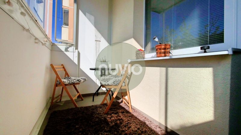 Balkon se dvěma skládacími židlemi a kobercem v 2-pokojovém bytě.